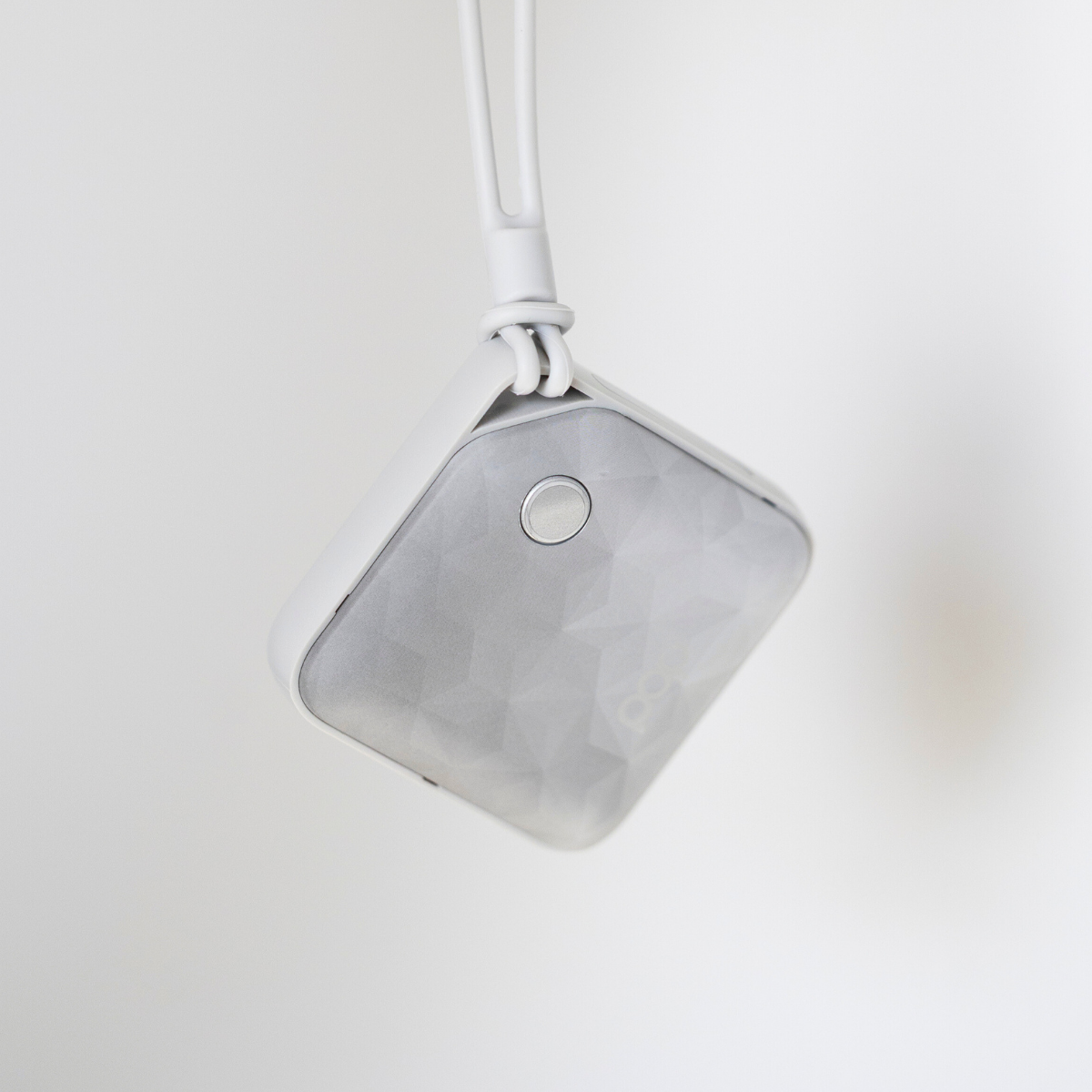 A Charcoal colored USB Rechargeable Handwarmer dangling into the image from the wrist strap with a white background