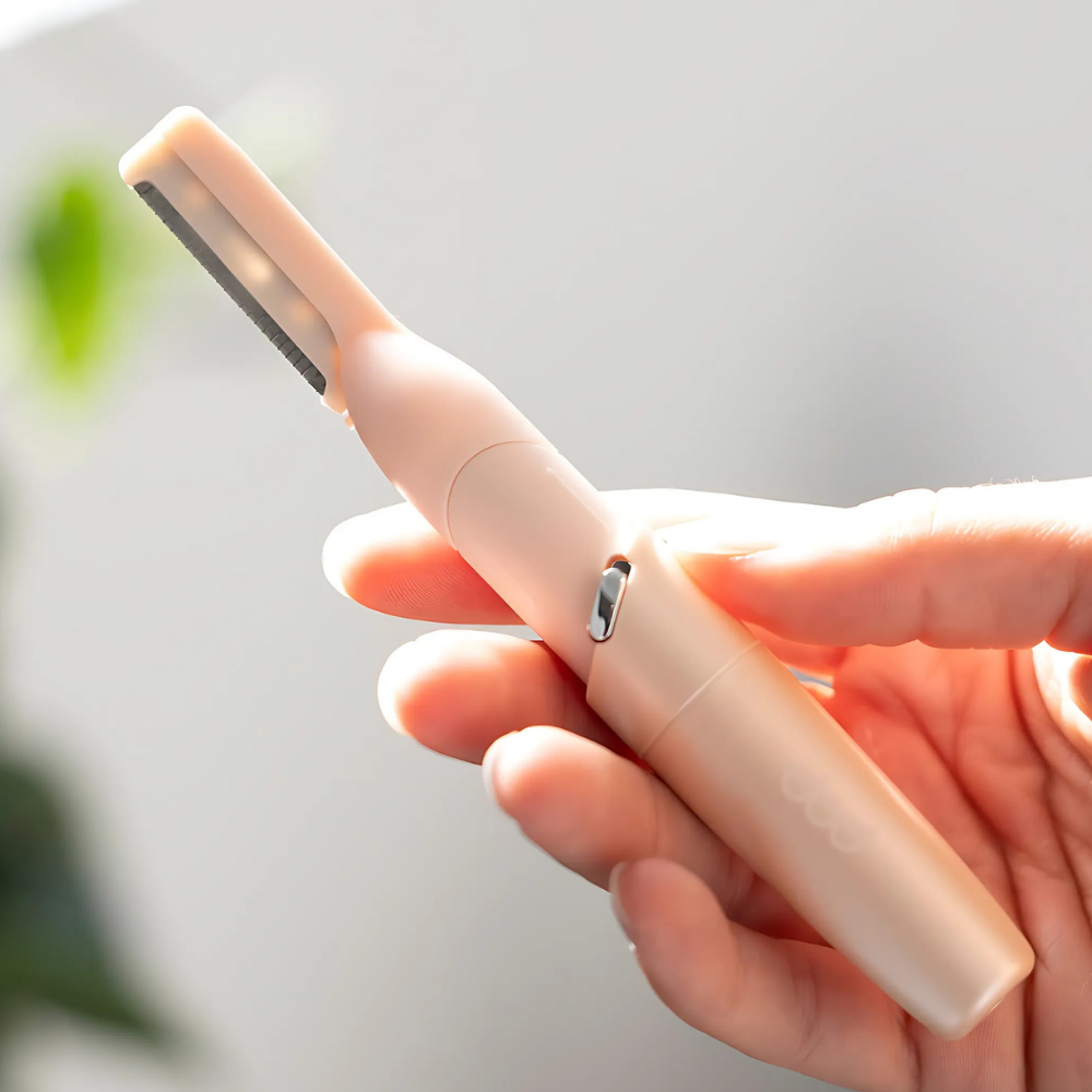 Hand holding a pink Hair Planer against a light background