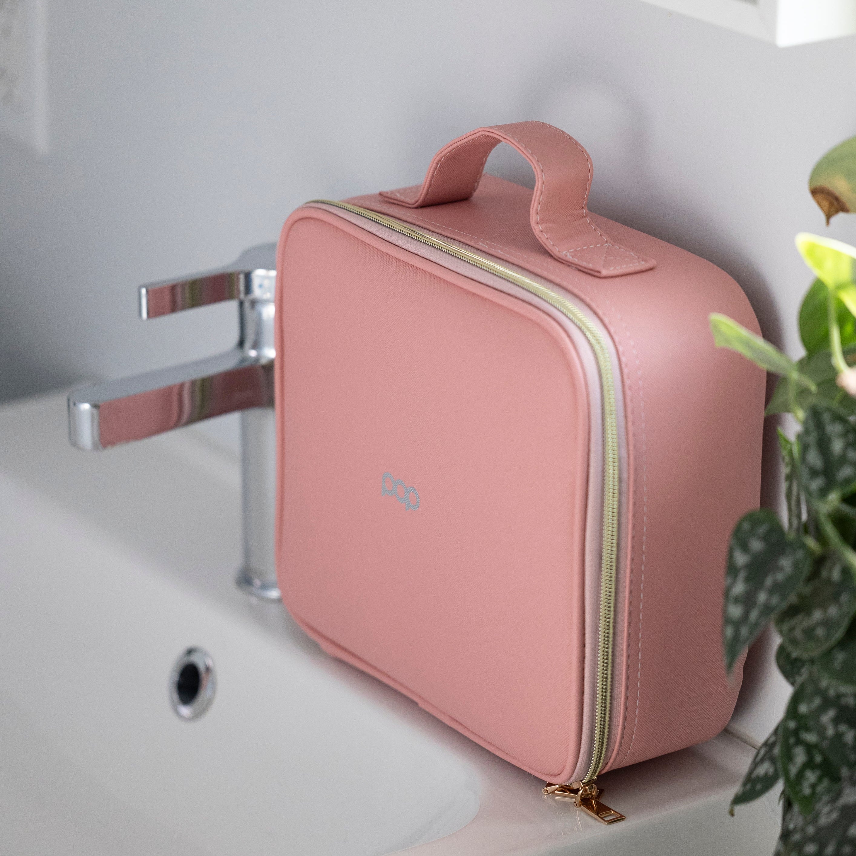 LED Makeup and Nailcare Cosmetic Case in Rose Pink sitting on a bathroom counter, closed