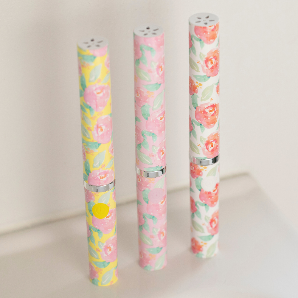 Three floral-patterned toothbrushes on a light background