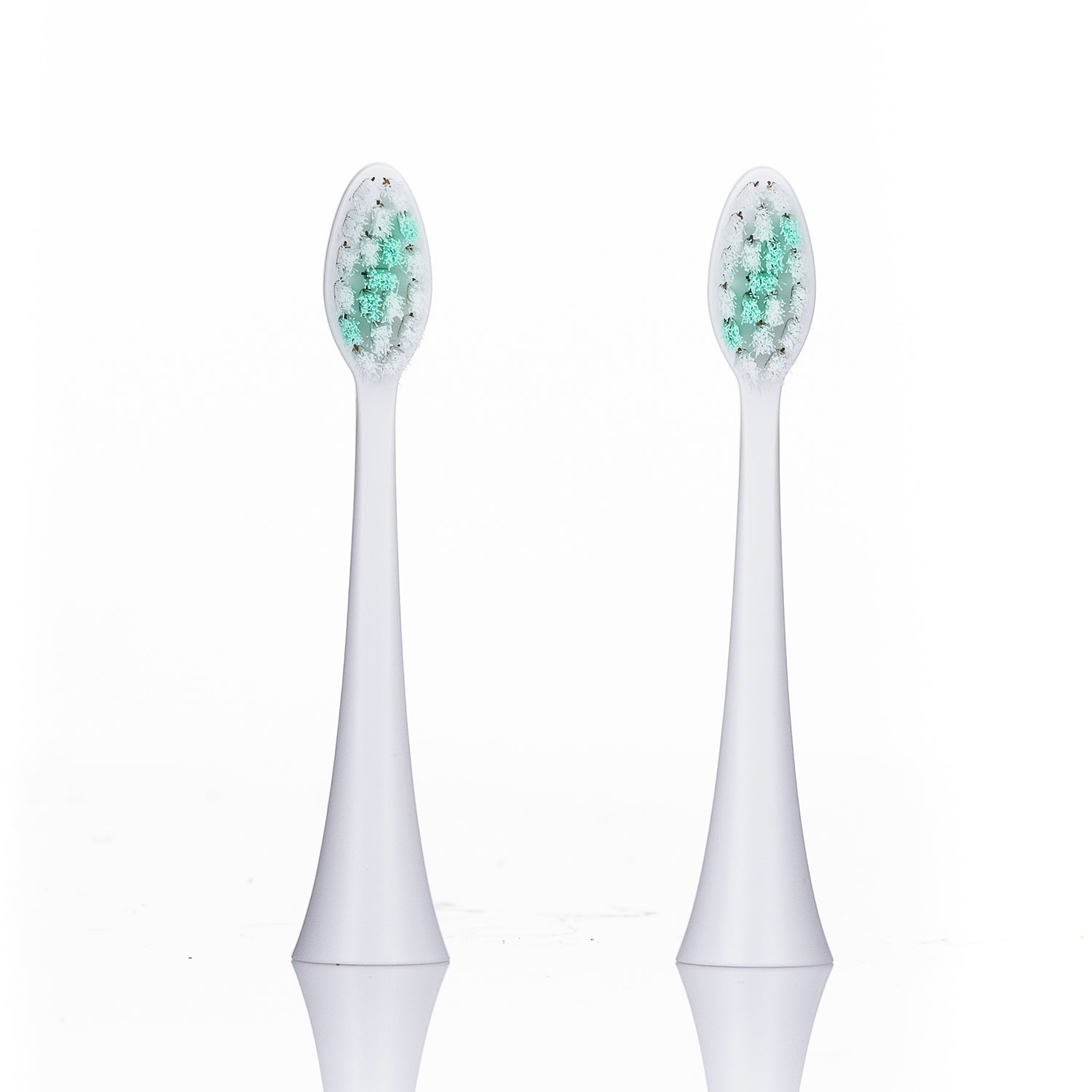 Two white electric toothbrush heads with green bristles on a white background