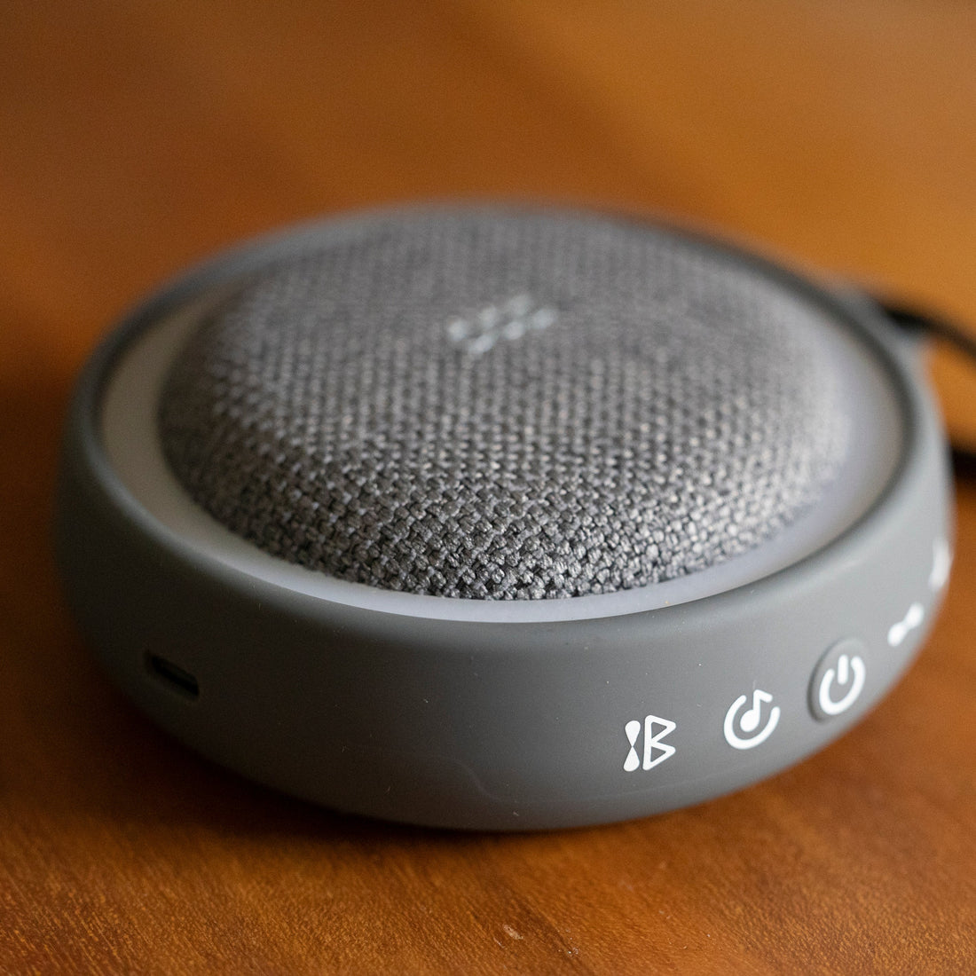 Gray sound machine sitting on a wood table