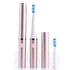 Rose gold electric toothbrush with two brush heads on a white background