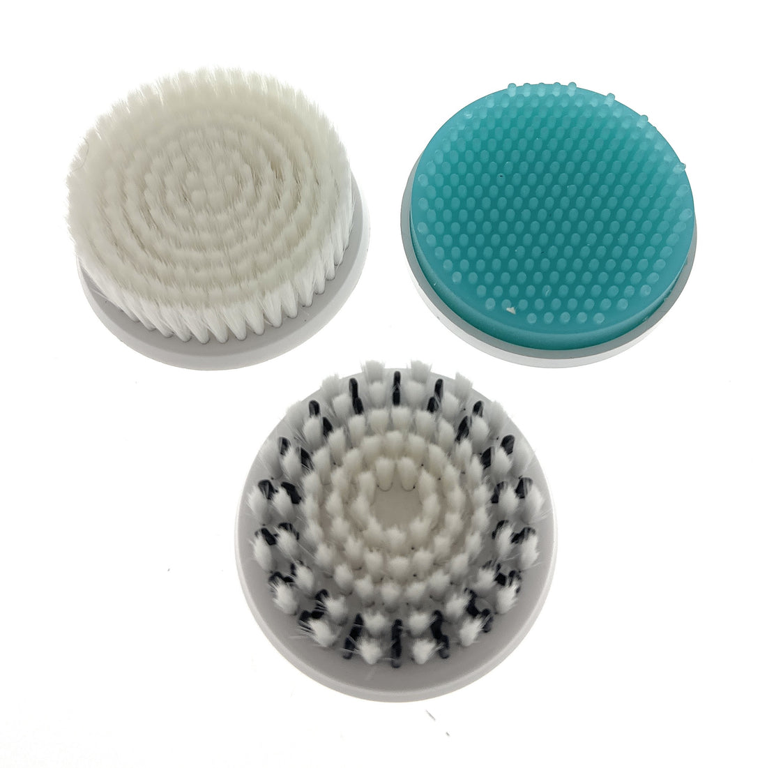Three circular replacement brushes with different bristle patterns on a white background
