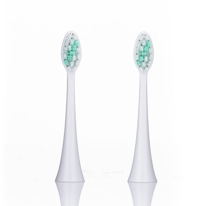 Two white electric toothbrush heads with green bristles on a white background